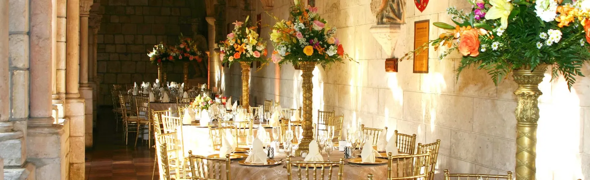 Exterior view of Coral Gables Country Club with palm trees, a golf course, and a clubhouse