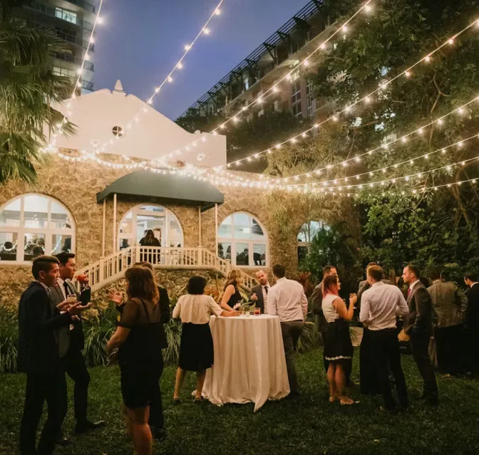 Exterior view of Coral Gables Country Club with palm trees, a golf course, and a clubhouse