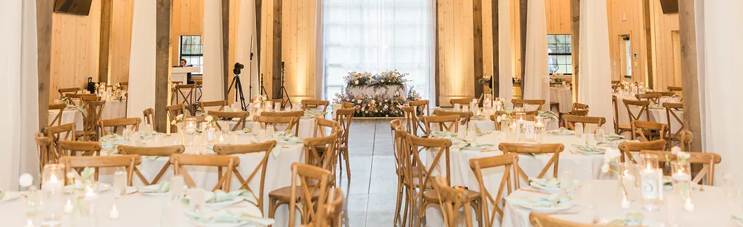 Indoor wedding ceremony setup at Trelis 925 with brick walls, white chairs, and a wooden triangle arch