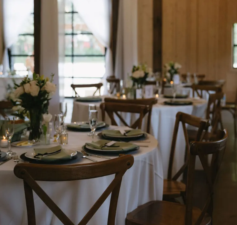 Indoor wedding ceremony at Trellis 925 with draped ceilings, string lights, white chairs, and brick walls for an intimate ambiance