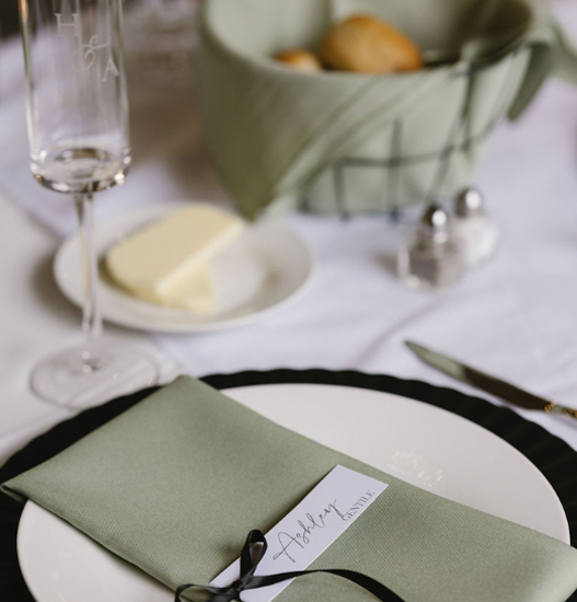 Elegant reception hall with draped ceilings, brick walls, string lights, and floral centerpieces at Trellis 925