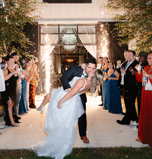 Trellis 925 indoor ceremony setup with white chairs, draped ceilings and string lights creating a warm atmosphere