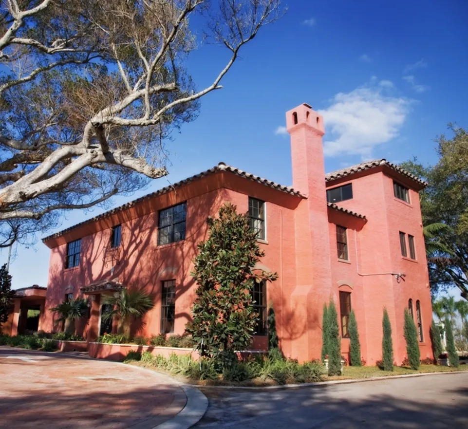 Exterior view of Thalatta Estate with palm trees, a golf course, and a clubhouse