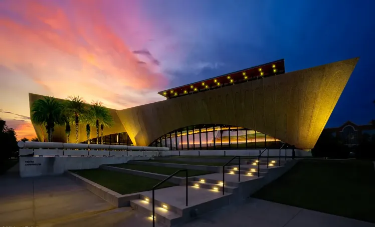 Indoor reception at Winter Park Events Center with round tables, minimalist decor, and large glass windows at dusk