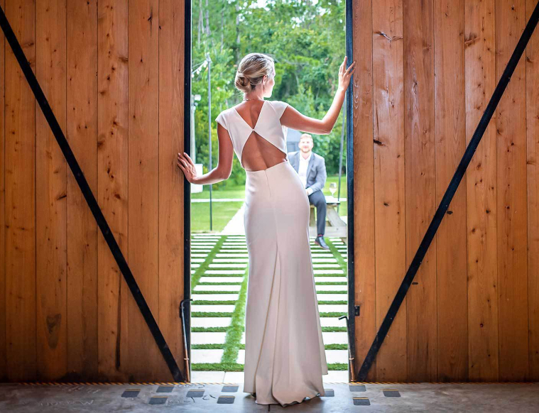 Reception setup with farmhouse tables and Chiavari chairs in rustic barn setting