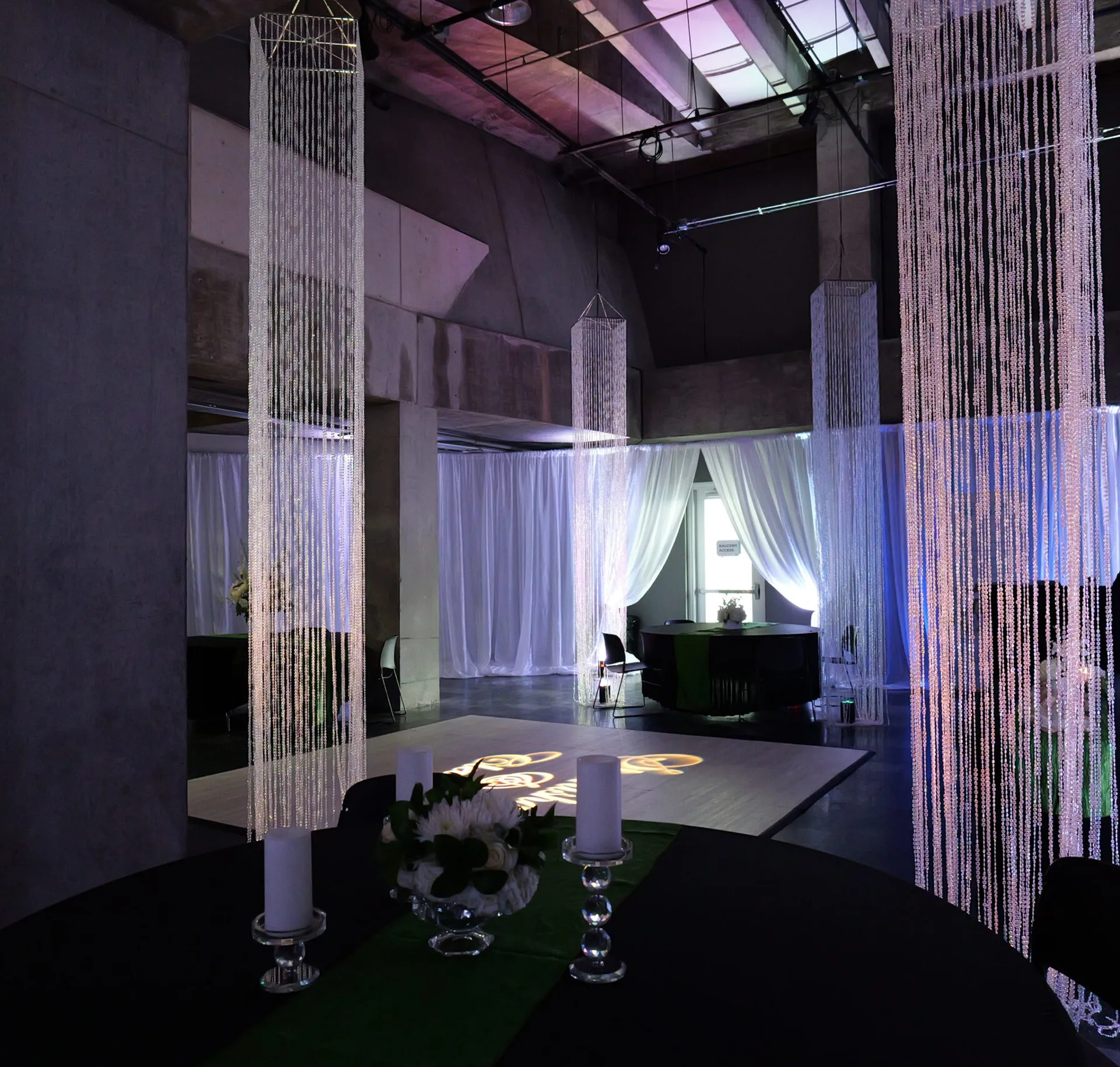 Elegant indoor reception at MOSI with black linens, crystal beaded columns, candlelight, and a lighted dance floor
