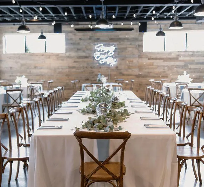 Rustic chic wedding reception setup with floral decor and wooden accents at The West Events