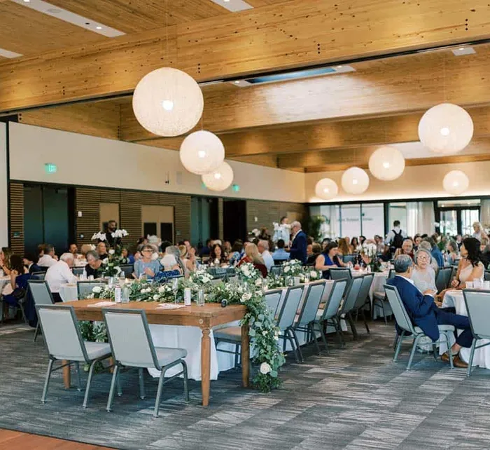 Outdoor wedding setup at Bonnet Springs Park with central dance floor, round tables under a tent, and trees in the background