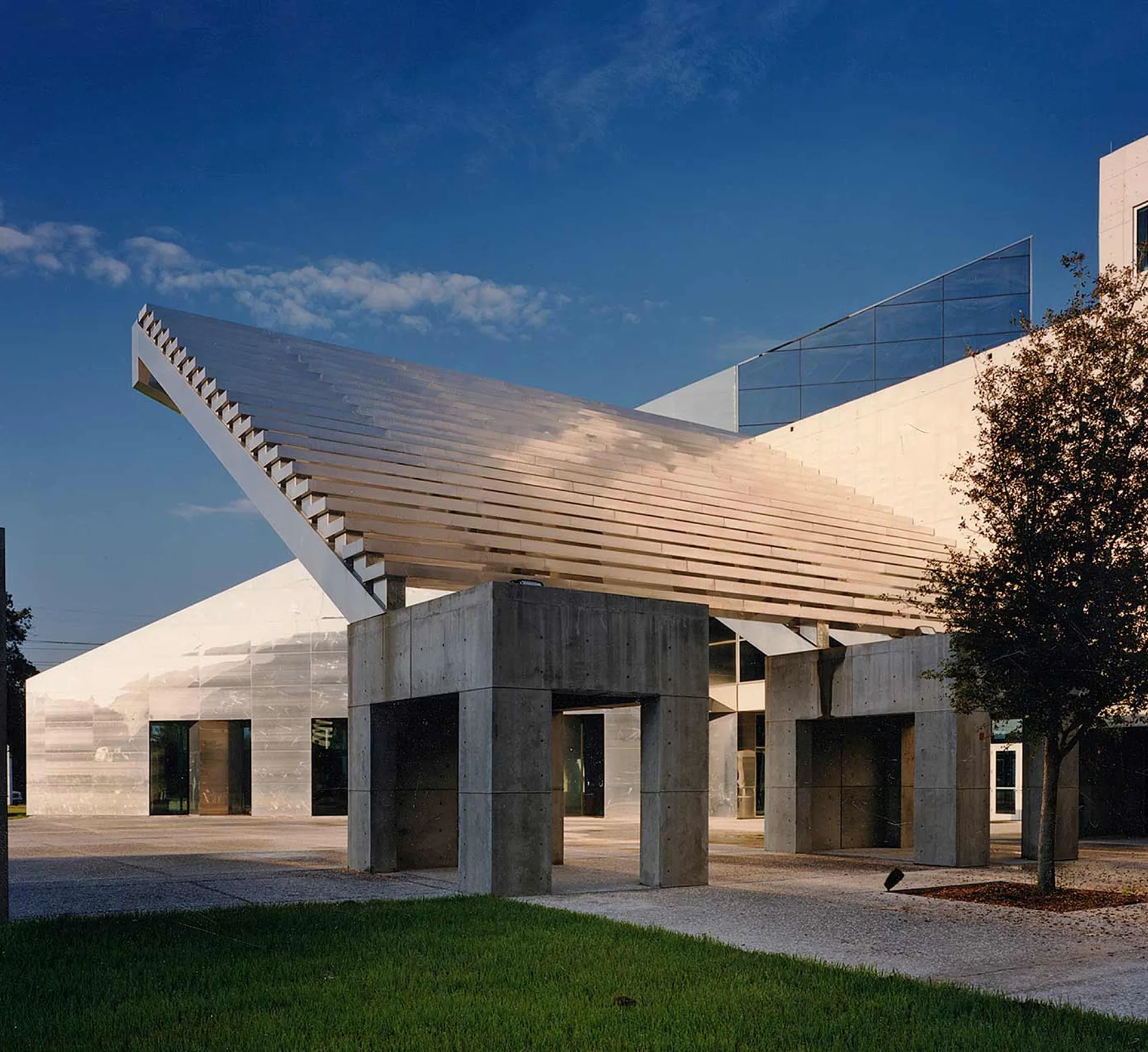 Modern entrance architecture at MOSI with white louvered canopy, concrete portals, and landscaped plaza