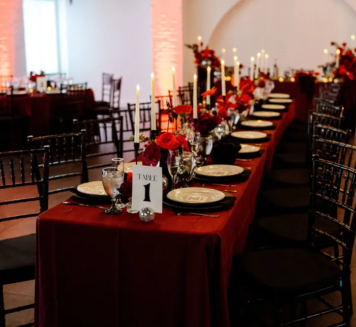 Indoor wedding ceremony setup at Trelis 925 with brick walls, white chairs, and a wooden triangle arch