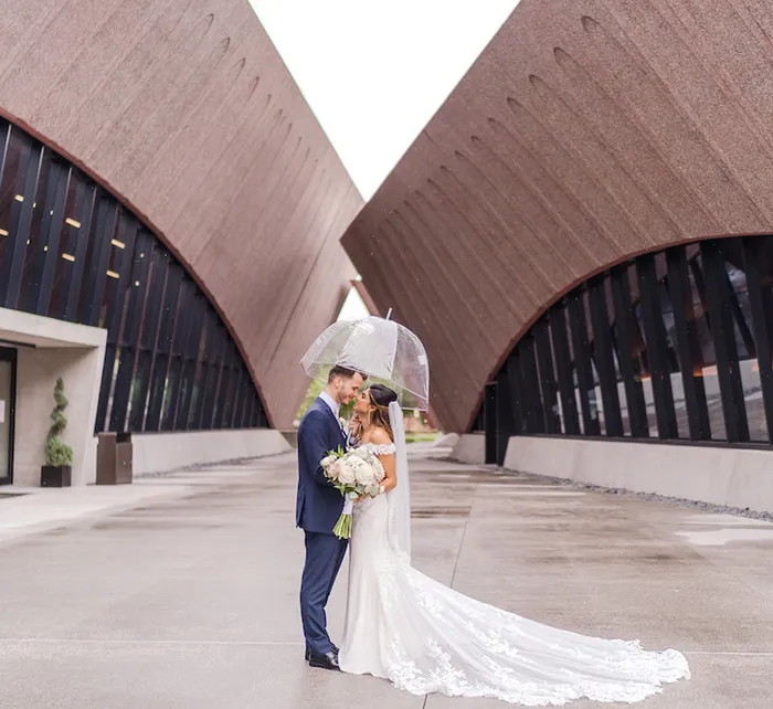 Outdoor ceremony setup at Winter Park Events Center with white chairs and palm trees under modern architecture
